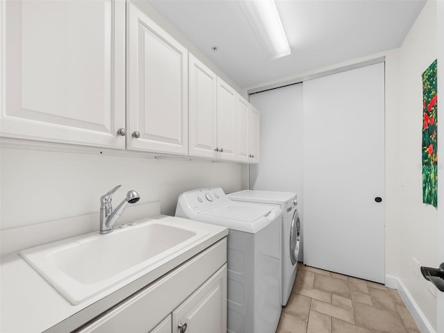 laundry room featuring separate washer and dryer, sink, and cabinets