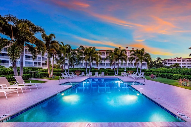 pool at dusk featuring a patio