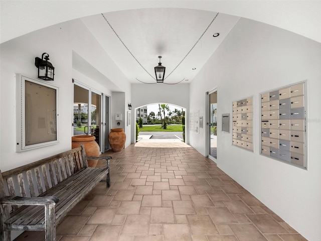 interior space featuring mail boxes, a chandelier, and high vaulted ceiling