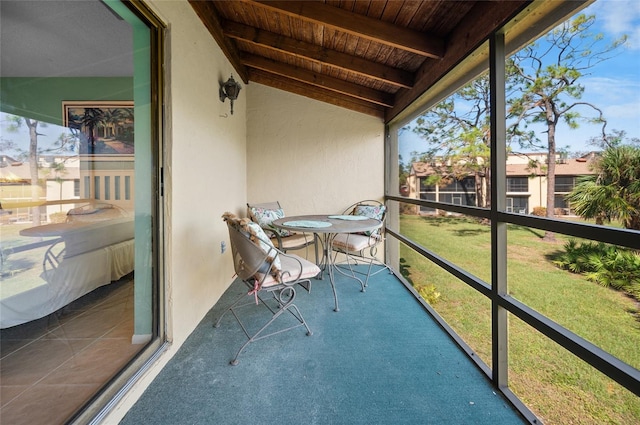 unfurnished sunroom featuring vaulted ceiling with beams and wooden ceiling