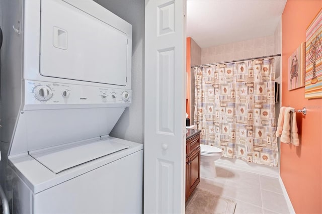 laundry area featuring stacked washer and clothes dryer and light tile patterned floors