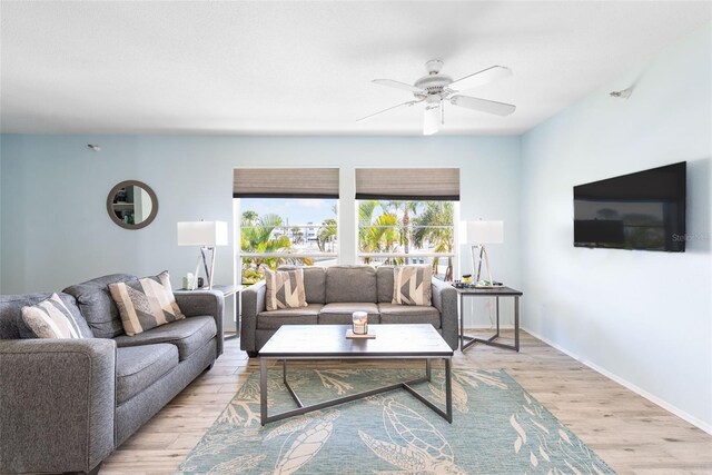 living room with light wood-type flooring and ceiling fan