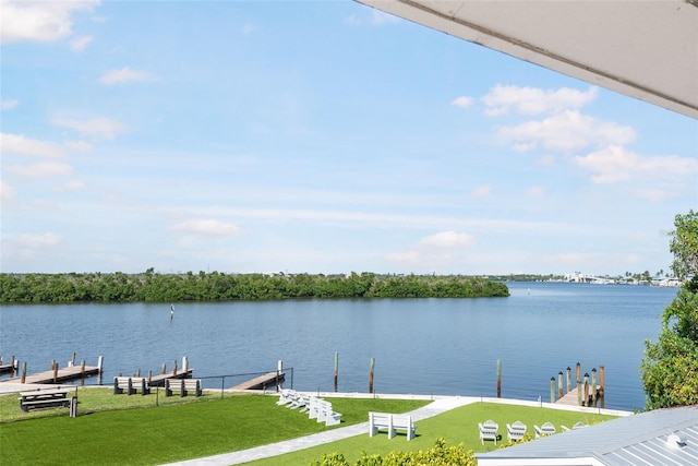 view of dock with a lawn and a water view