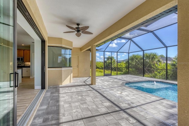 view of swimming pool with a patio, a lanai, and ceiling fan