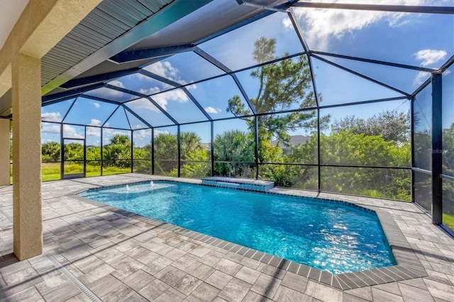 view of pool with a patio and glass enclosure