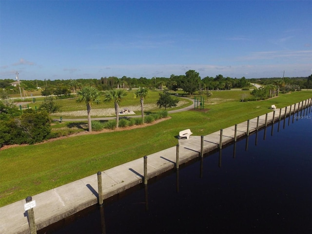 view of home's community with a rural view, a yard, and a water view