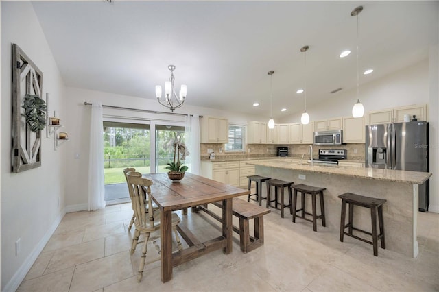 tiled dining area featuring sink, lofted ceiling, and a notable chandelier