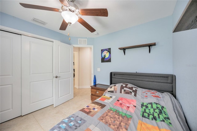 bedroom with ceiling fan, light tile patterned flooring, and a closet