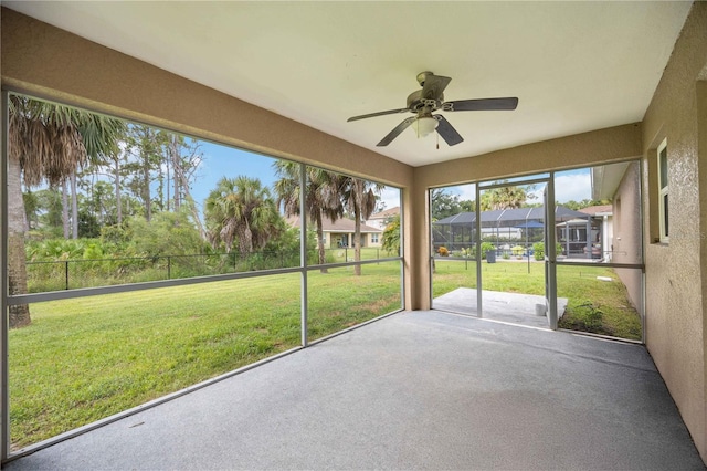 unfurnished sunroom with ceiling fan