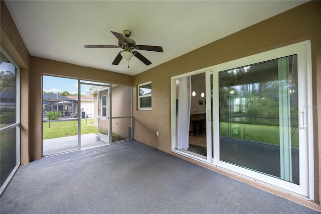 unfurnished sunroom with ceiling fan