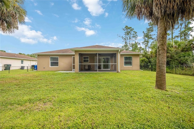 back of property featuring a lawn and a sunroom