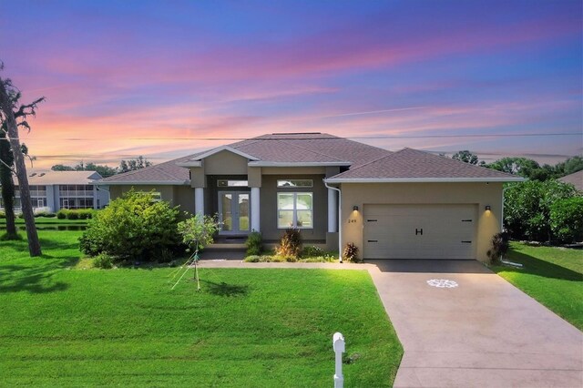 prairie-style home featuring a garage and a yard