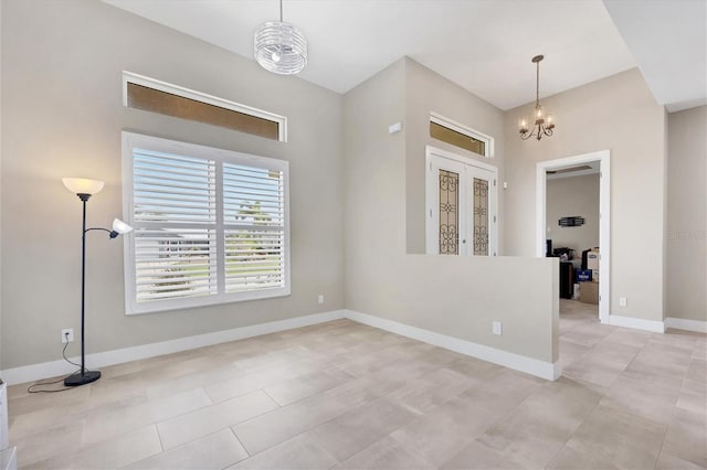 tiled spare room with an inviting chandelier