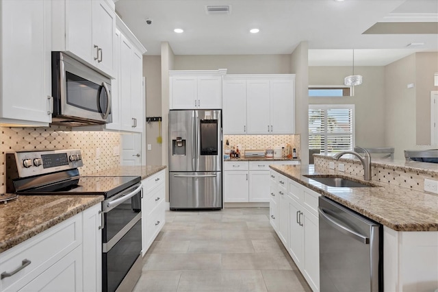 kitchen with white cabinets, appliances with stainless steel finishes, and stone counters