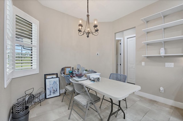 dining area featuring light tile patterned flooring and a notable chandelier