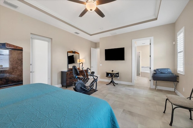 bedroom featuring connected bathroom, a tray ceiling, and ceiling fan