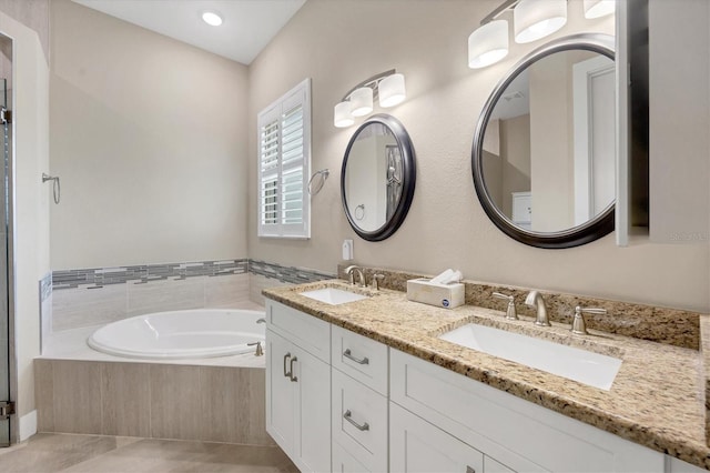 bathroom with vanity, a relaxing tiled tub, and tile patterned floors