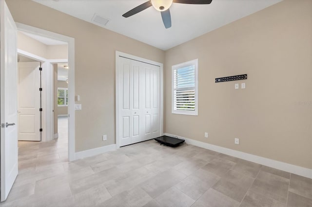 unfurnished bedroom featuring ceiling fan and a closet