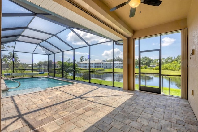 view of pool featuring a patio, a water view, ceiling fan, and glass enclosure