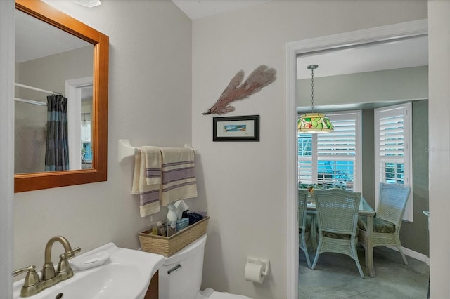 bathroom with walk in shower, tile patterned flooring, toilet, and sink