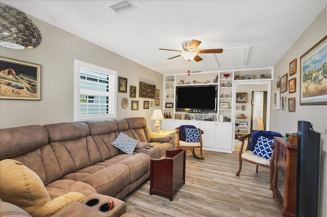 living room with ceiling fan, light hardwood / wood-style flooring, and built in shelves