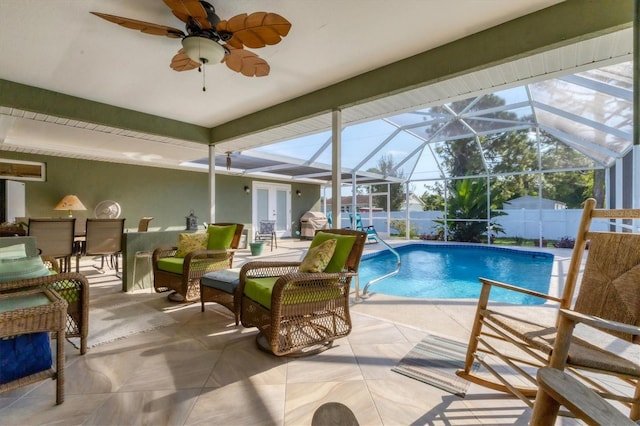 view of swimming pool with ceiling fan, glass enclosure, and a patio