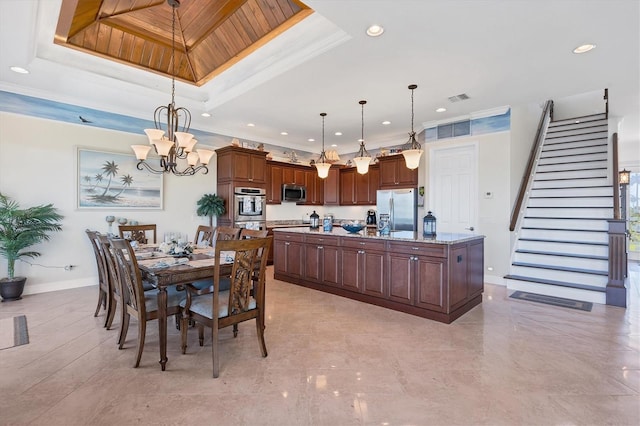 dining room with ornamental molding, a chandelier, and a raised ceiling