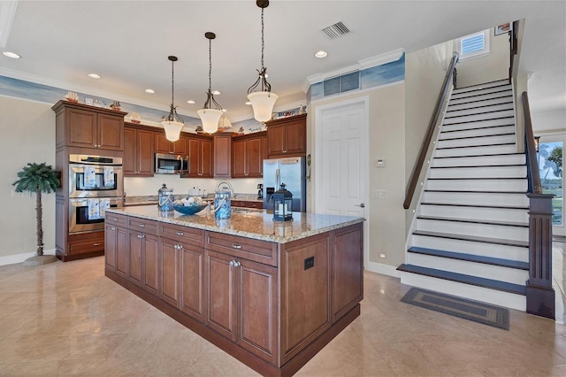 kitchen with light stone counters, hanging light fixtures, a kitchen island, stainless steel appliances, and ornamental molding