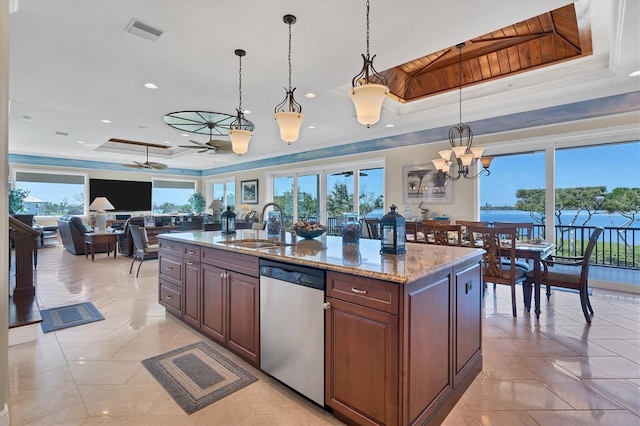 kitchen with pendant lighting, a tray ceiling, a healthy amount of sunlight, and stainless steel dishwasher