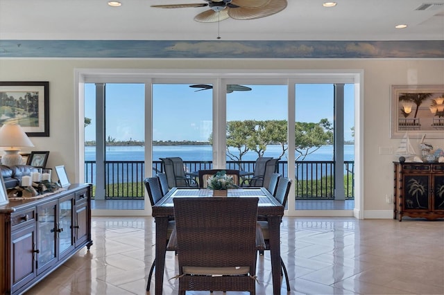 dining area featuring a water view, ceiling fan, and a healthy amount of sunlight