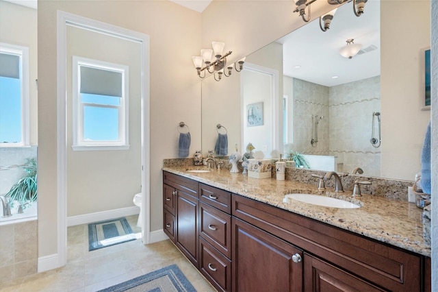 bathroom with a tile shower, vanity, toilet, and tile patterned floors