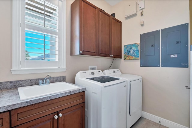 laundry room featuring cabinets, electric panel, sink, and washing machine and dryer