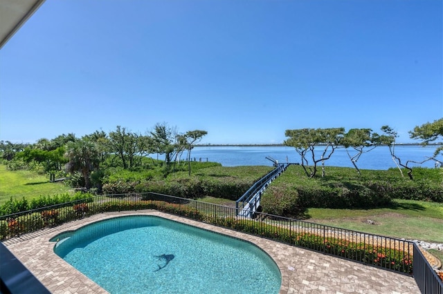 view of swimming pool featuring a patio and a water view