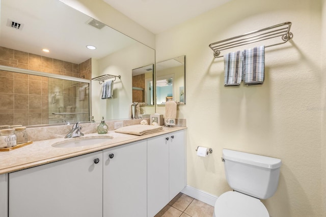 bathroom with walk in shower, vanity, toilet, and tile patterned floors