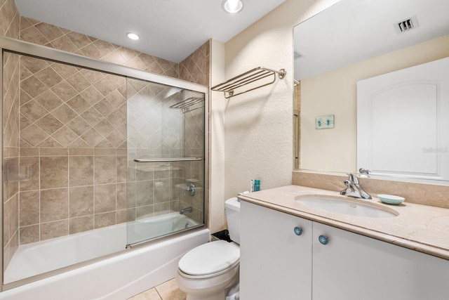 full bathroom featuring tile patterned flooring, shower / bath combination with glass door, vanity, and toilet