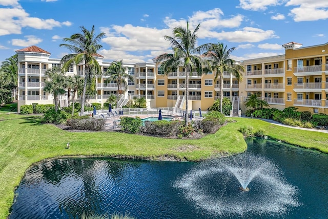 view of property featuring a water view and a community pool