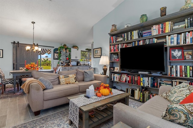 living room featuring an inviting chandelier, lofted ceiling, hardwood / wood-style flooring, and sink