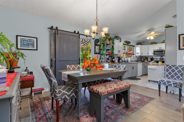 dining area featuring ceiling fan with notable chandelier, sink, and a barn door