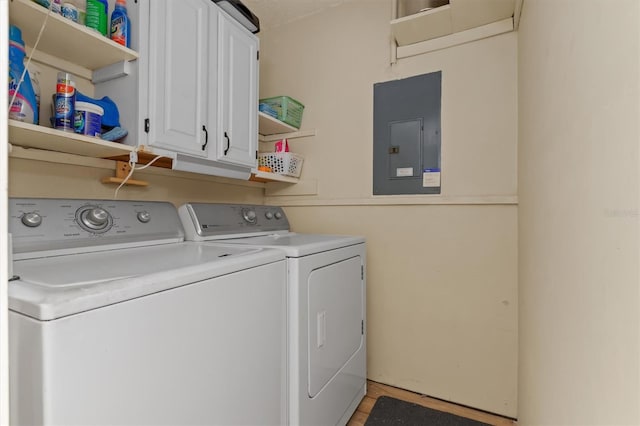 washroom featuring cabinets, electric panel, and washer and clothes dryer