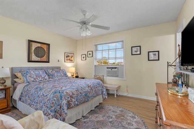 bedroom with a textured ceiling, light hardwood / wood-style floors, and ceiling fan