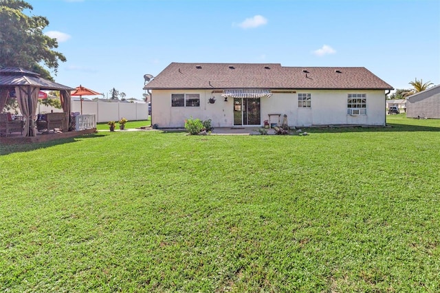 rear view of house with a patio area, a gazebo, and a yard