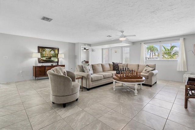 tiled living room featuring ceiling fan and a textured ceiling