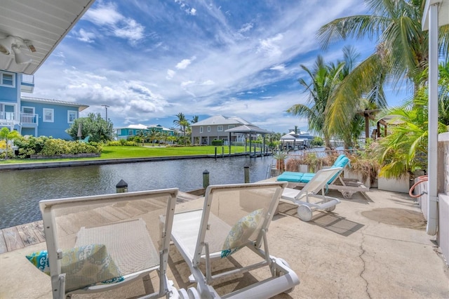 view of patio with a boat dock and a water view