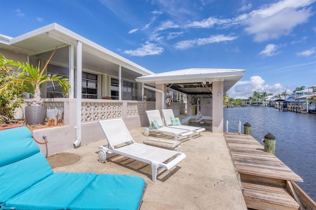 view of patio featuring a water view and a dock