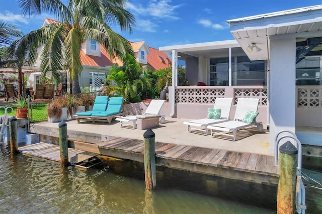 view of dock featuring a water view and a patio