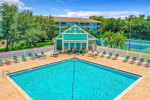 view of swimming pool featuring tennis court