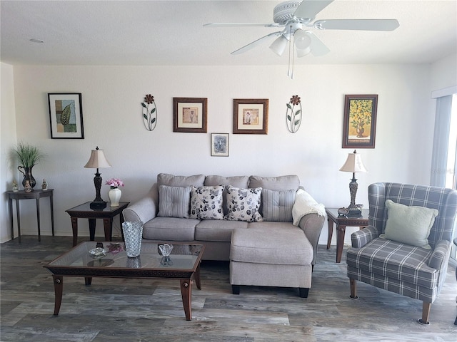 living room featuring a textured ceiling, ceiling fan, and dark wood-type flooring