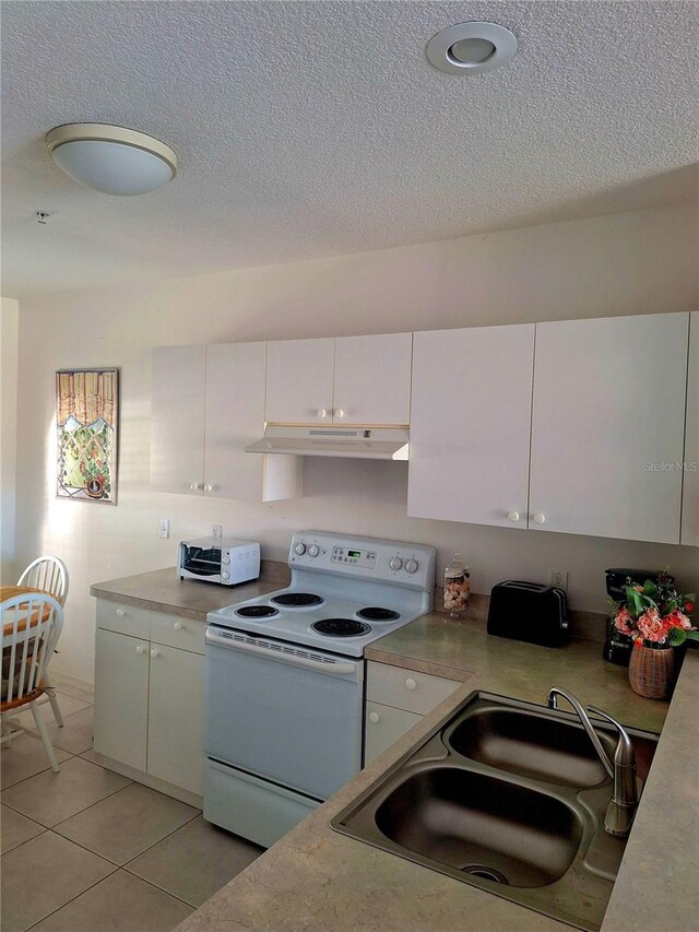 kitchen with white electric range, sink, a textured ceiling, light tile patterned flooring, and white cabinetry