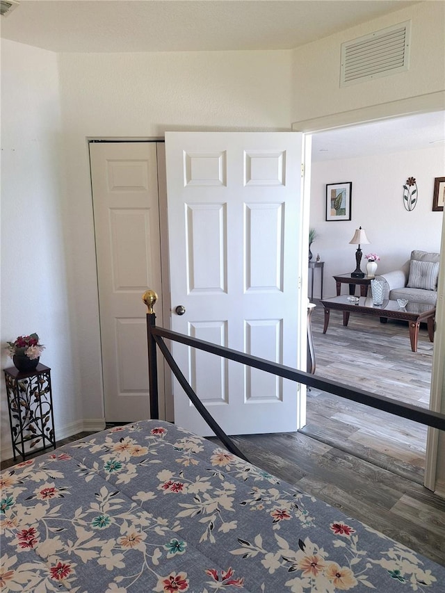 bedroom with dark hardwood / wood-style floors and a closet