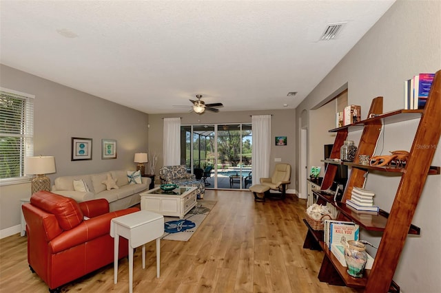 living room with light hardwood / wood-style floors and ceiling fan